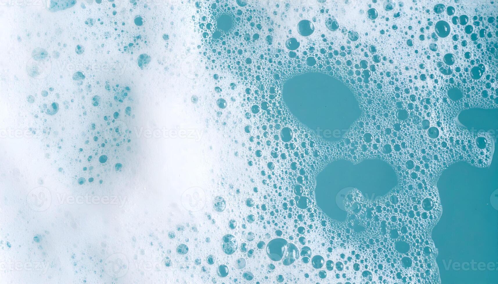 clean soap foam bubbles floating on light blue water surface, top view abstract hygiene texture for cleaning and freshness concept photo