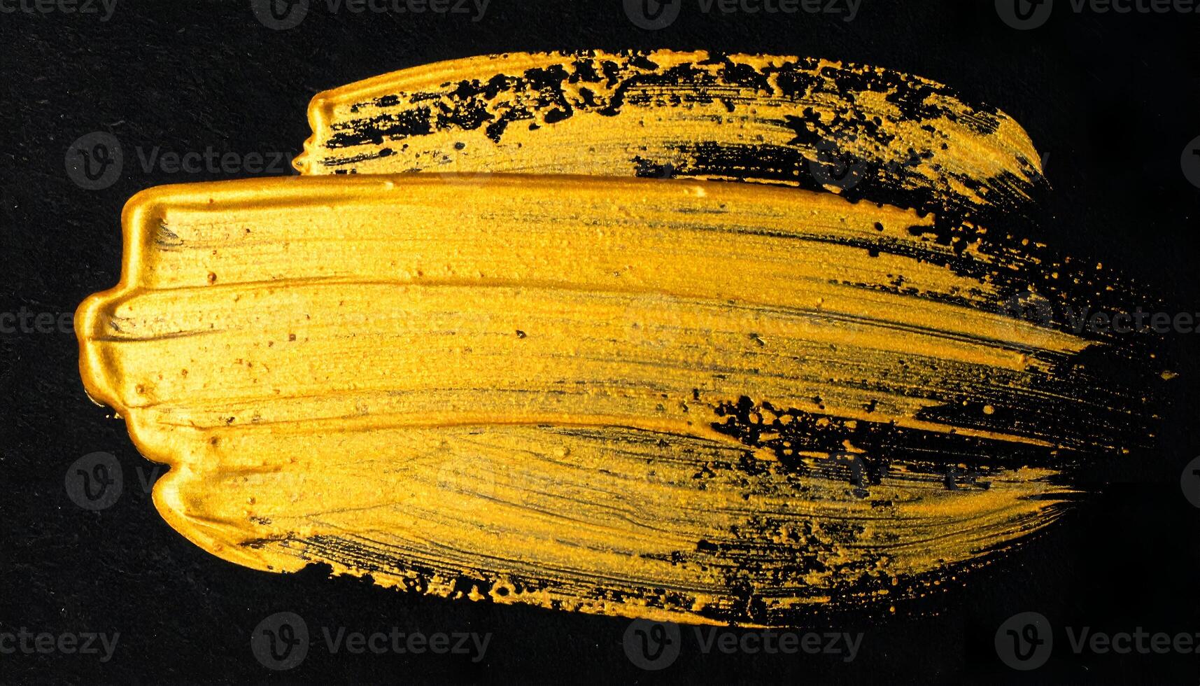 abstract gold brush stroke on black background, metallic paint smear texture for luxury design or artistic backdrop photo