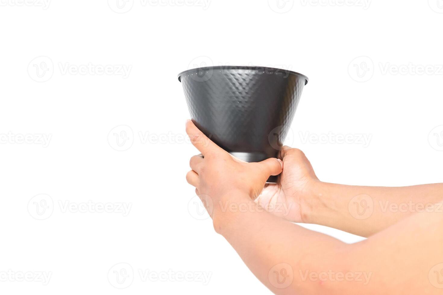 Hands holding a black metallic bucket, isolated on white background, studio shot photo