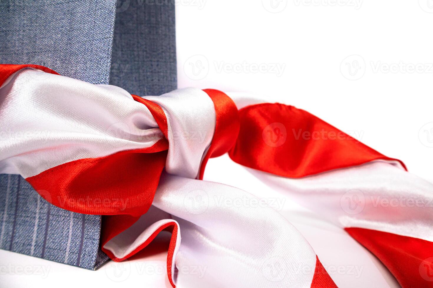 Elegantly Wrapped Gift Box with a Vibrant Red and White Ribbon on White Background photo