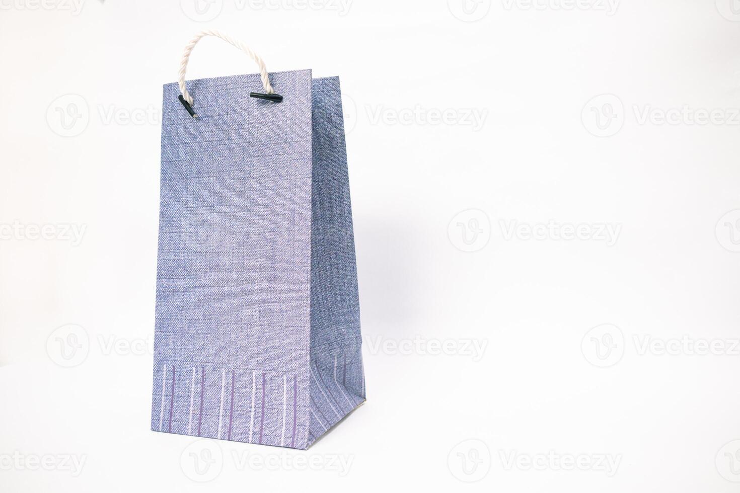 Elegant Light Blue Textured Gift Bag with Rope Handles on a White Background photo