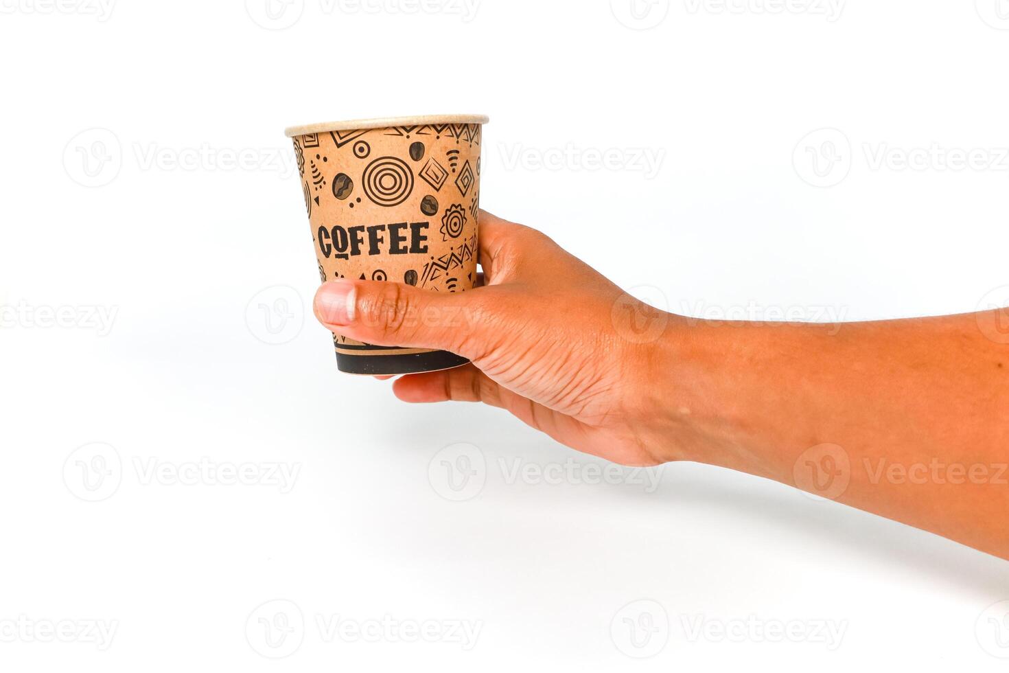 A person's hand holds a paper coffee cup against a clean white background, showcasing a simple and everyday moment photo