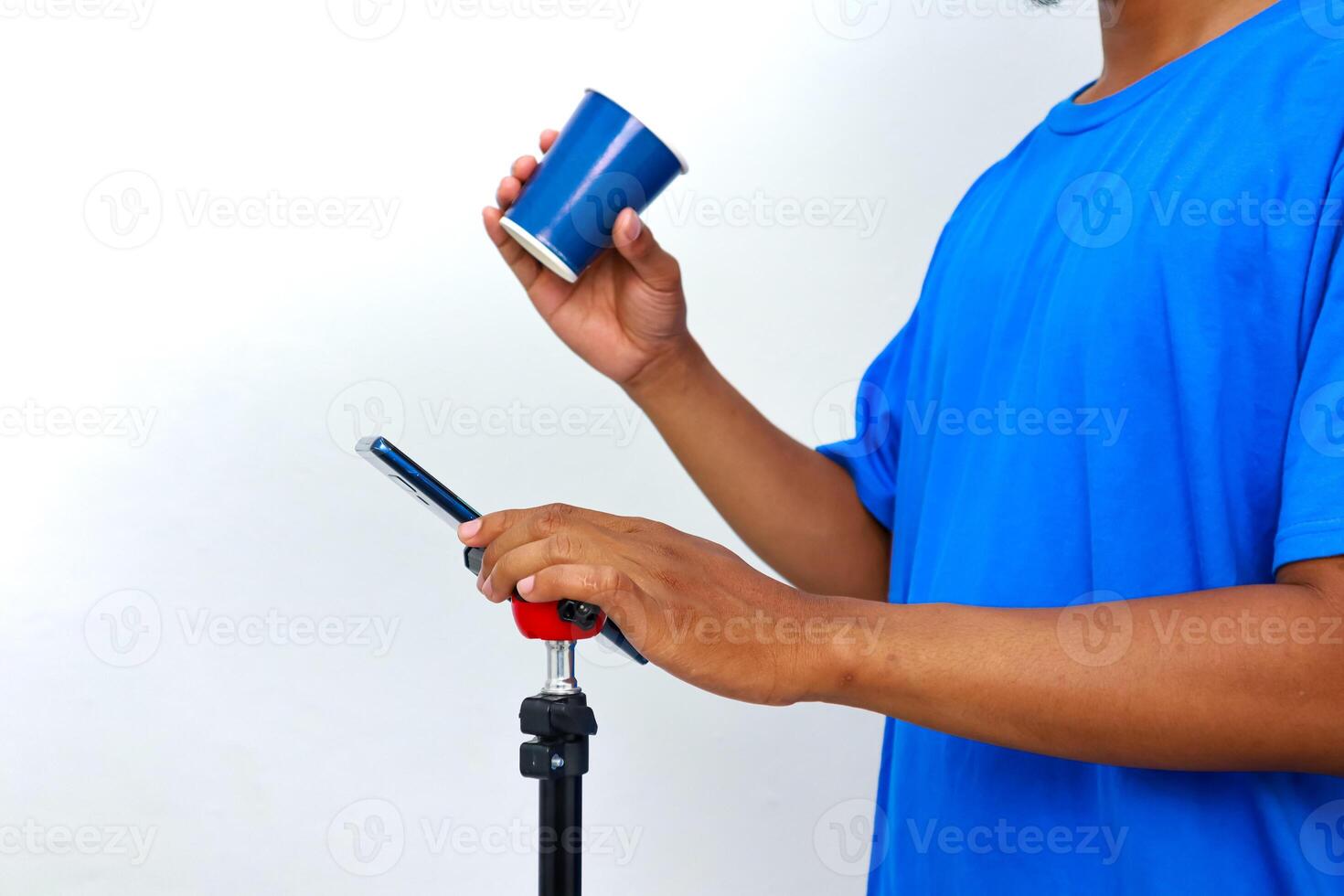 Holding Cup and Phone on Stand for Online Content Creation photo