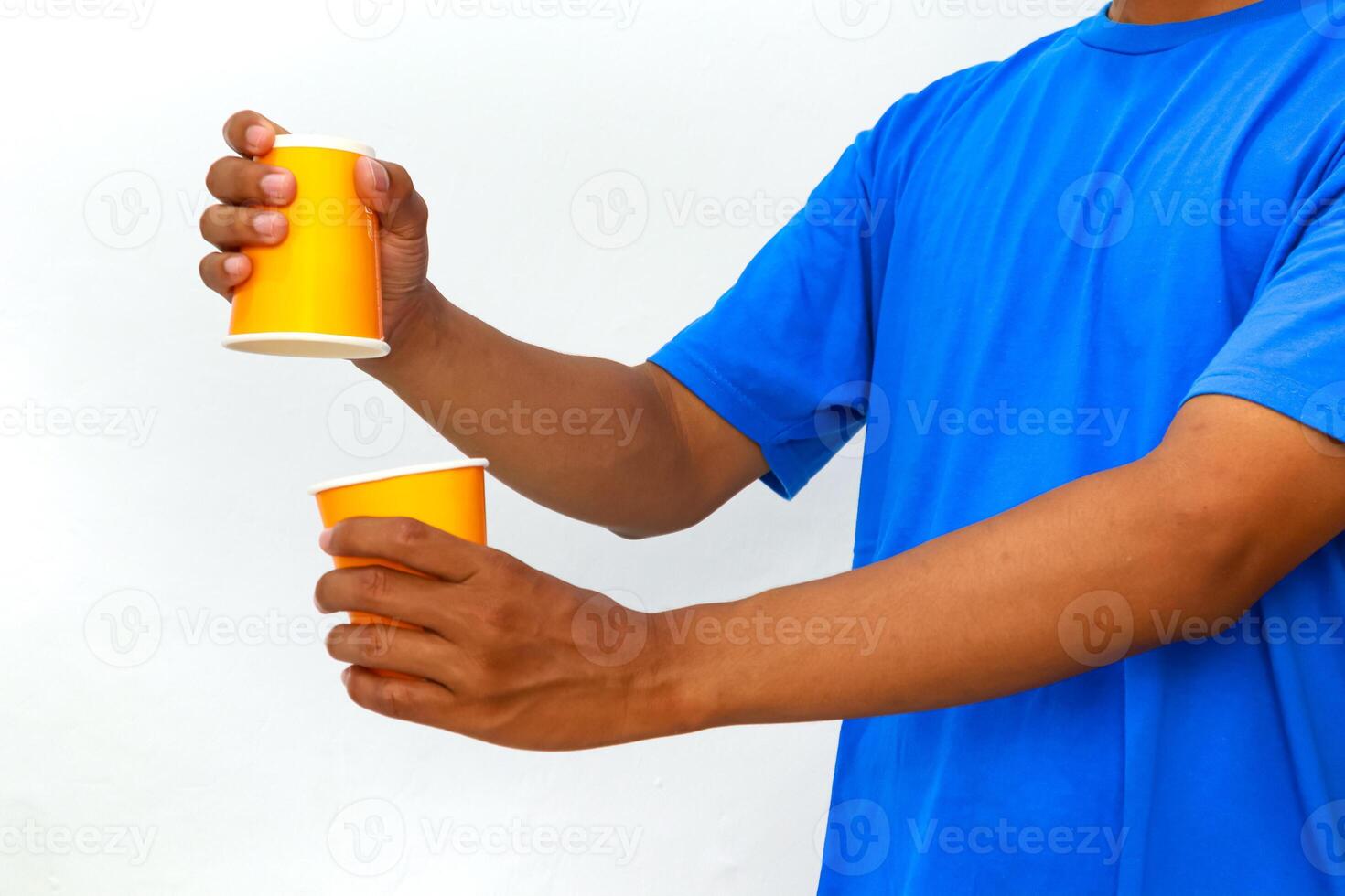 Person with two paper cups is preparing for a cup and ball street magic trick photo