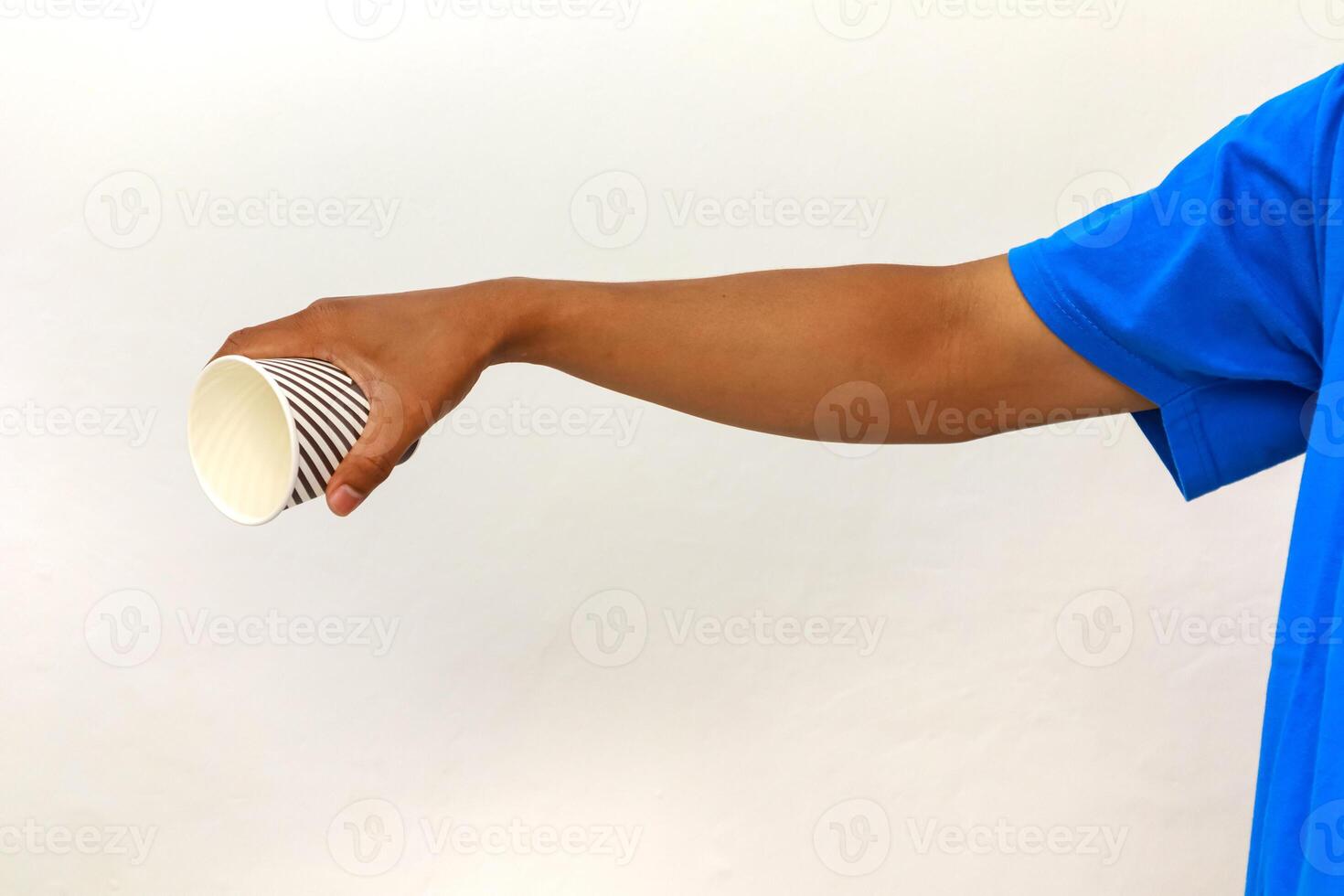 Hand holding a striped paper cup against a white background, wearing a blue shirt, isolated object for beverage or food promotion photo