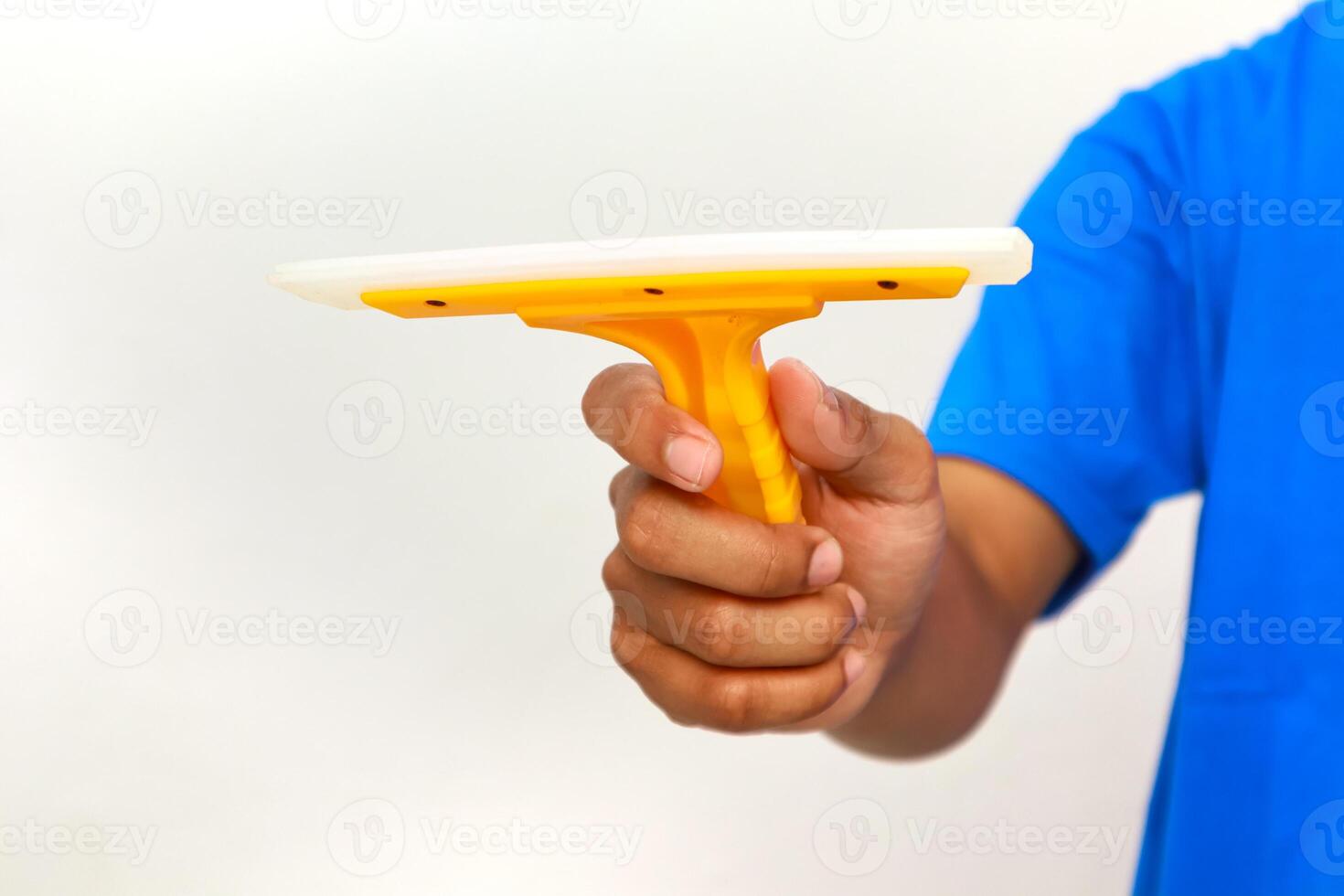A close-up shot of a hand holding a yellow and white squeegee on a white background photo