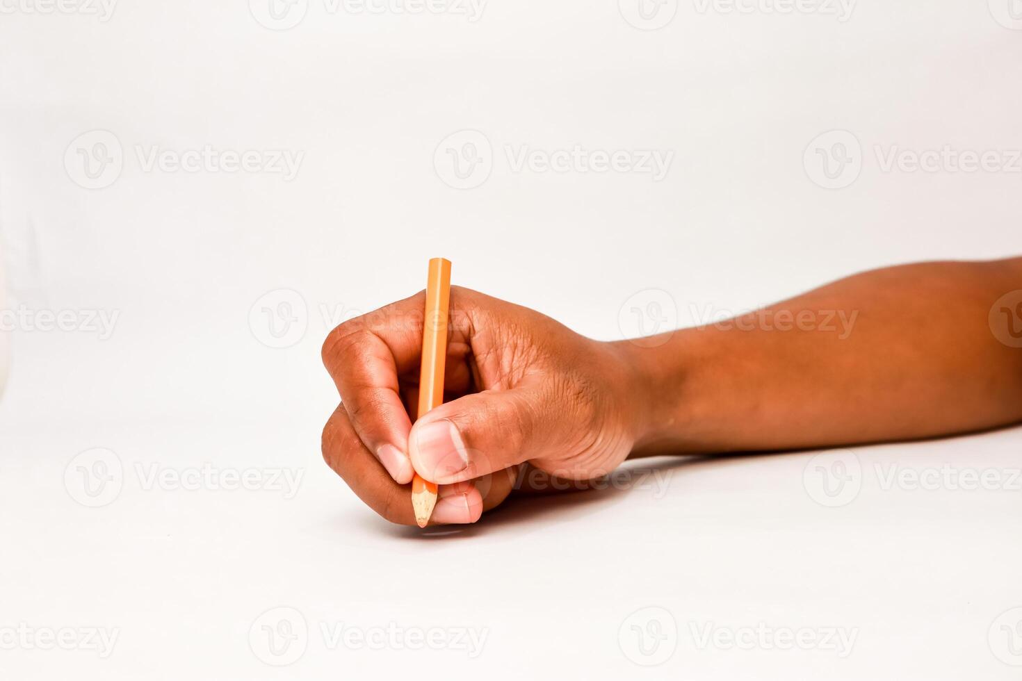 Close up of a hand holding a pencil on a white background ready to write photo
