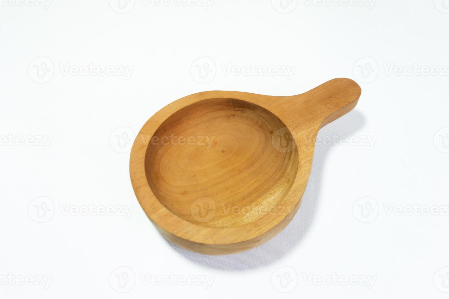 Close-up of empty wooden bowl with handle against white background representing natural and rustic kitchenware photo