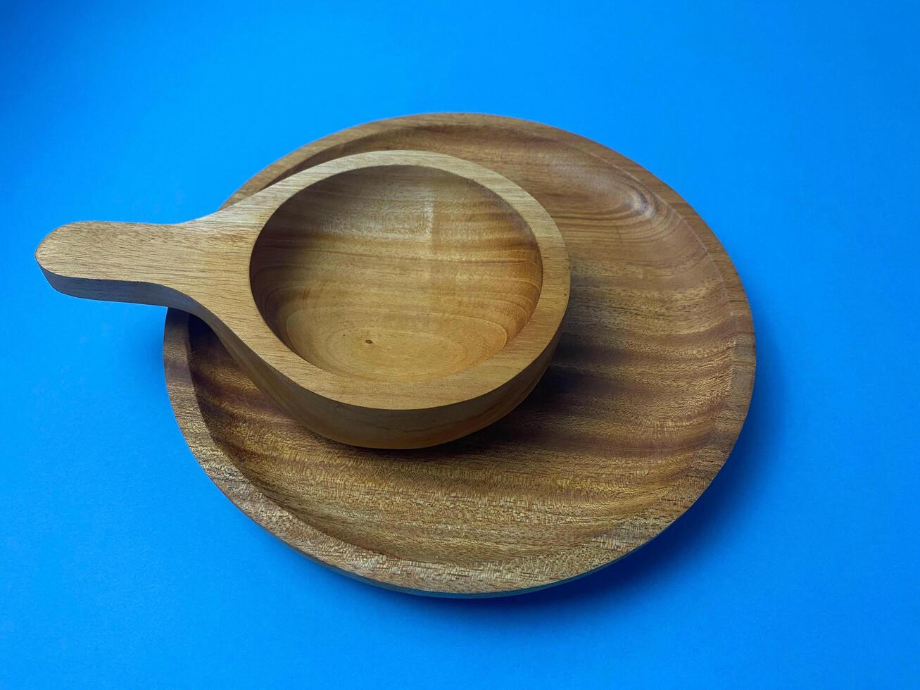 Wooden bowl and plate set creating a natural and minimalist aesthetic, shot on blue photo