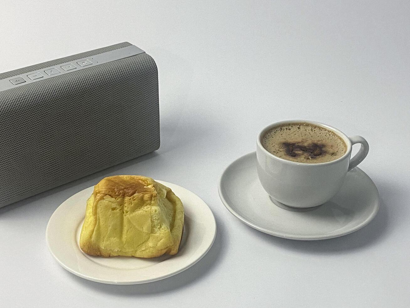 Breakfast Still Life with Audio Device, Coffee, and Pastry on White Background photo