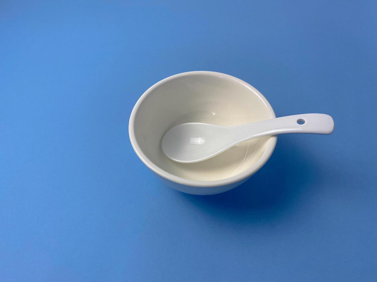 Elegant simplicity, White bowl and spoon on a serene blue backdrop image photo