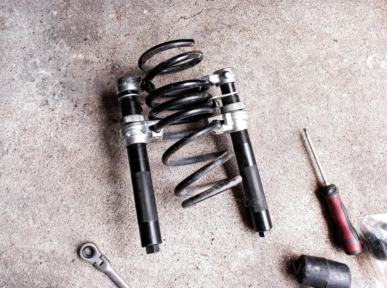 Coil spring compressor or Spring compressor, A tool for pressing springs to remove them from car shock absorbers or struts. photo