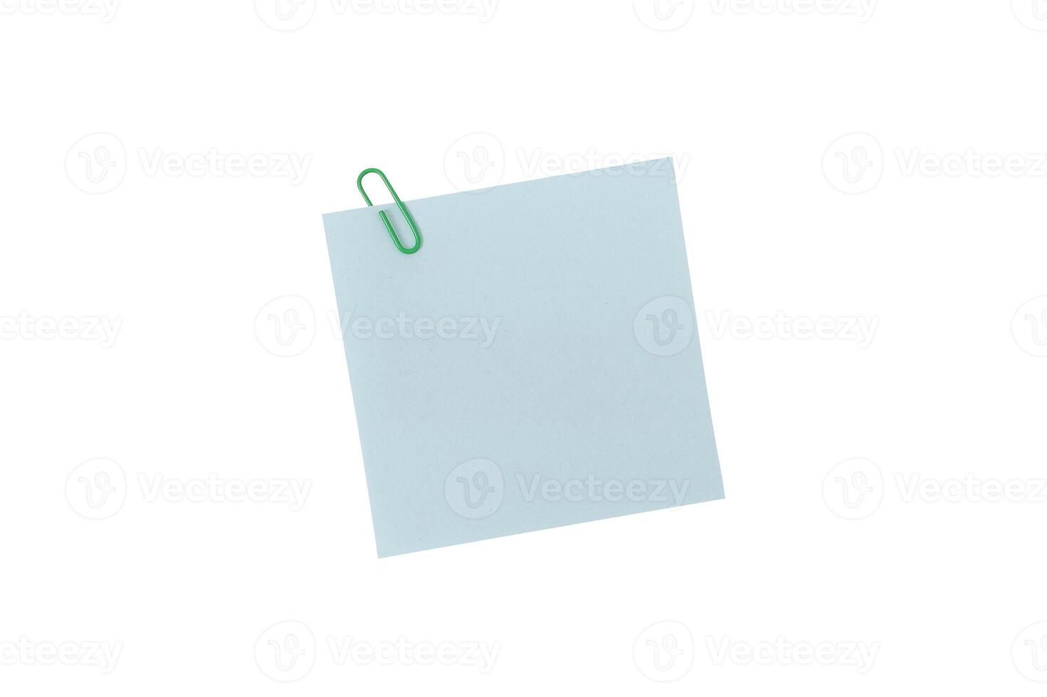 Post It Note or Sticky Note, A single green paperclip secures a blank light blue square note, isolated on a white background include clipping path photo