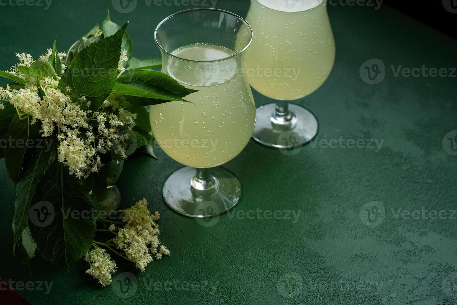 Carbonated elderflower drink. Flower summer kvass in glasses. Floral green background copy space photo