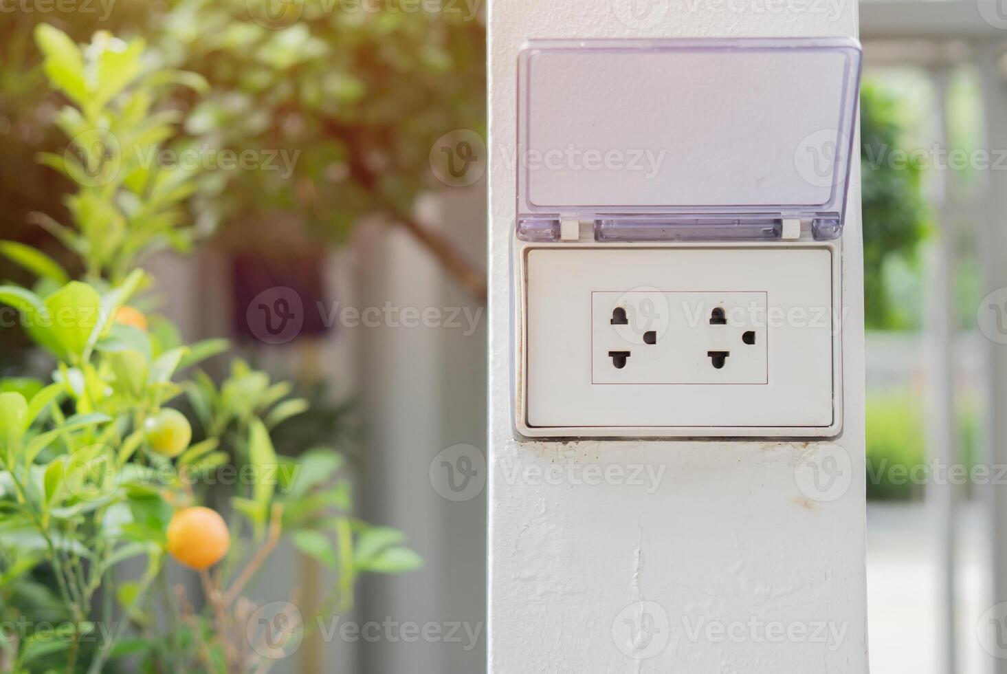 White plug on white wall with a garden in the background, plug socket, electric, plug outlet photo