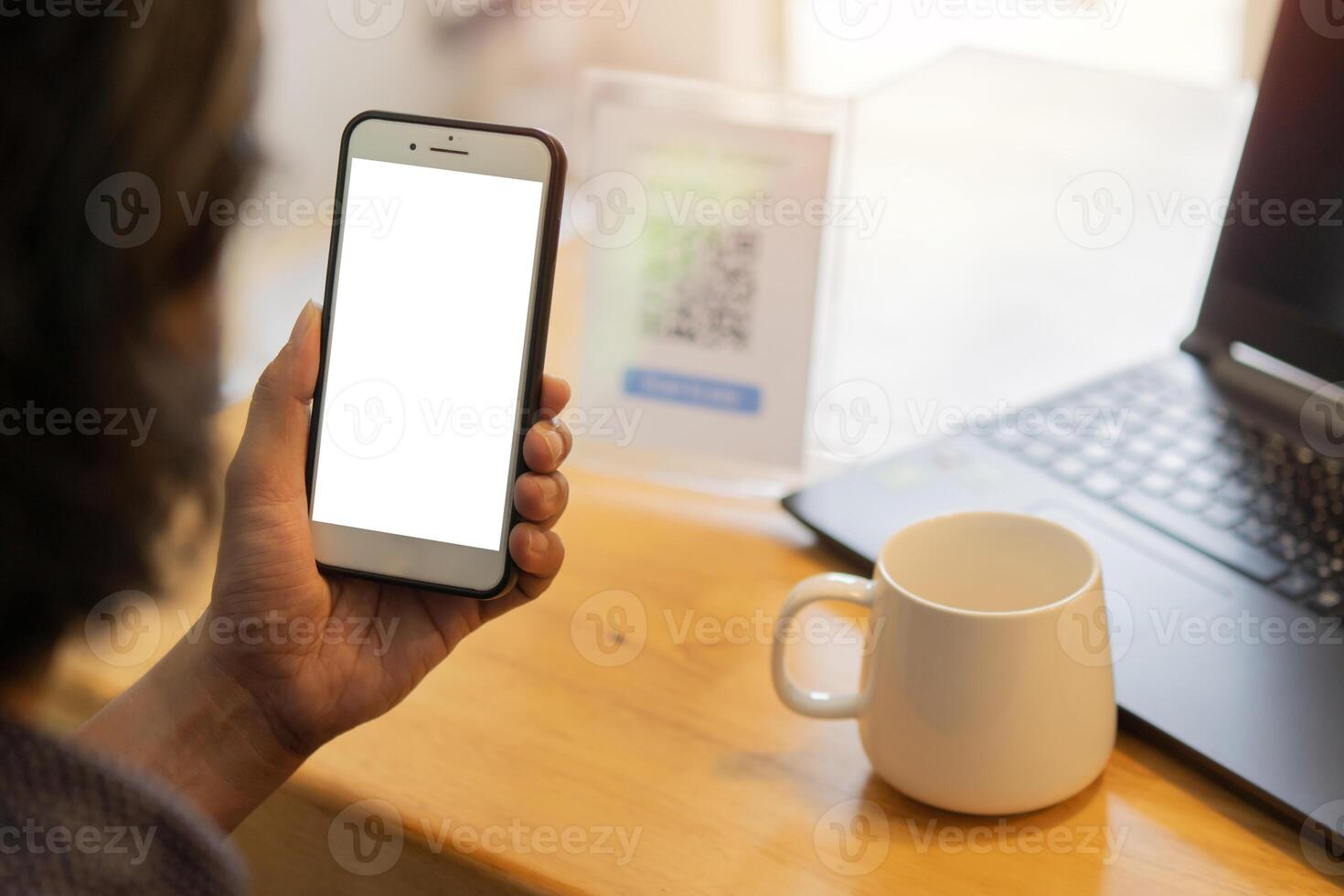 Unrecognizable man's hands on cafe or coffee shop desk, working and using the smart phone with isolate screen. photo