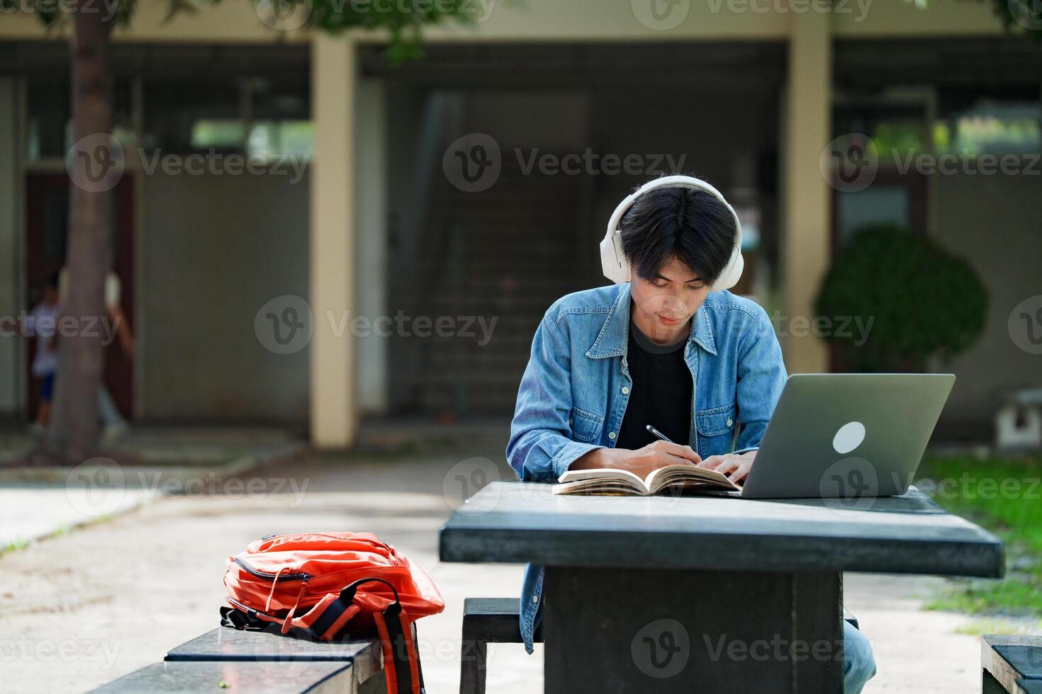 Man sitting and writing note lecture while prepare exam. photo