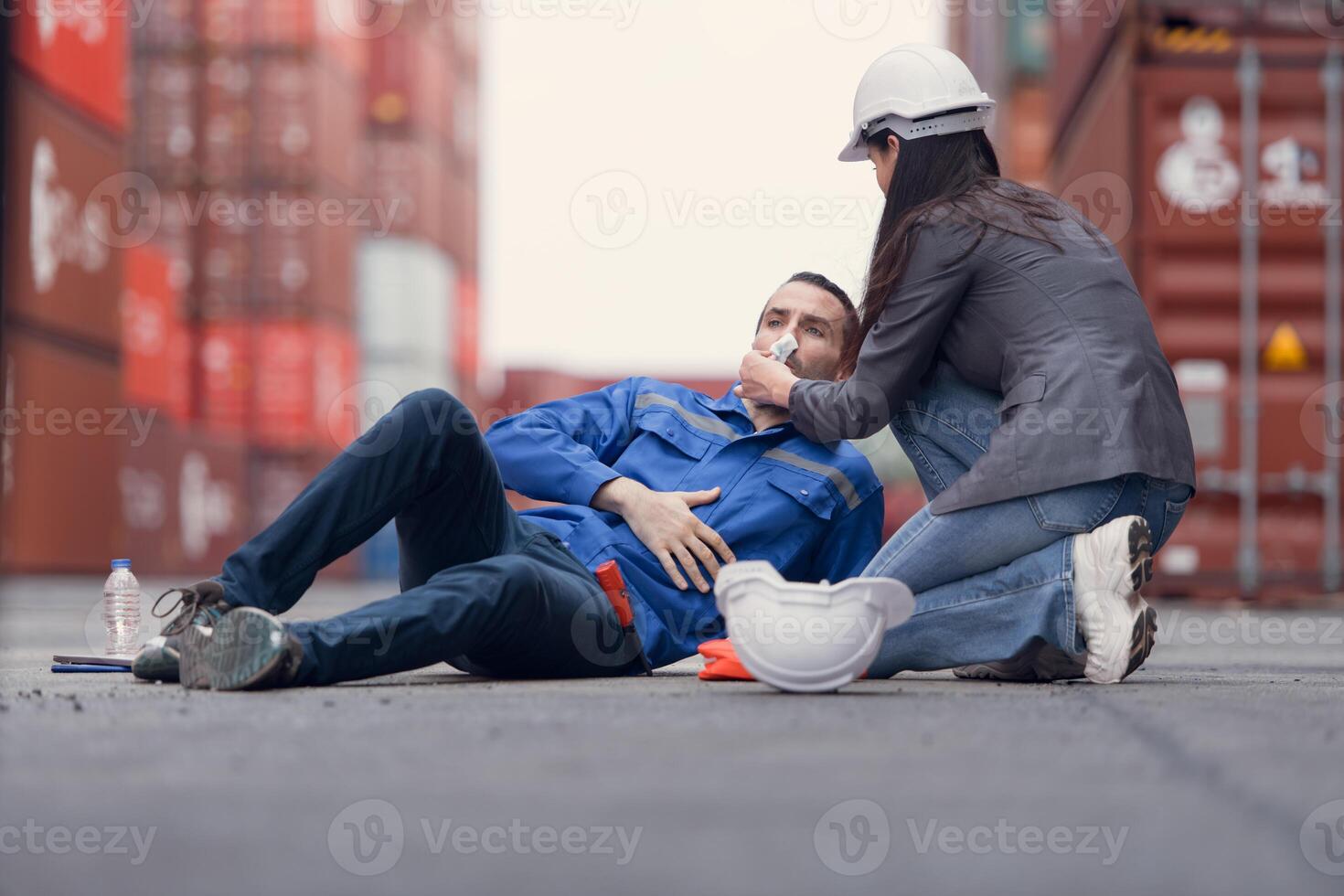 First aid for a container warehouse worker fainted while working in the bright sunlight and hot weather of a container storage yard,153 photo