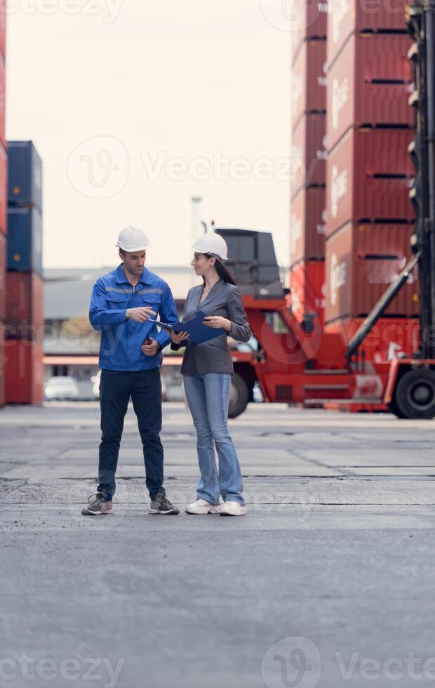 Container manufacturing manager and businesswomen survey the area to plan the storage and moving of goods in and out of the container storage area,149 photo