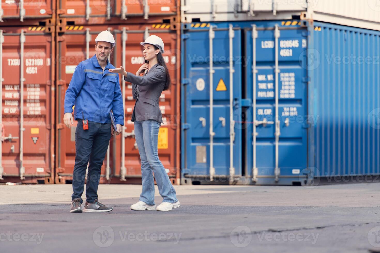 Container manufacturing manager and businesswomen survey the area to plan the storage and moving of goods in and out of the container storage area,144 photo