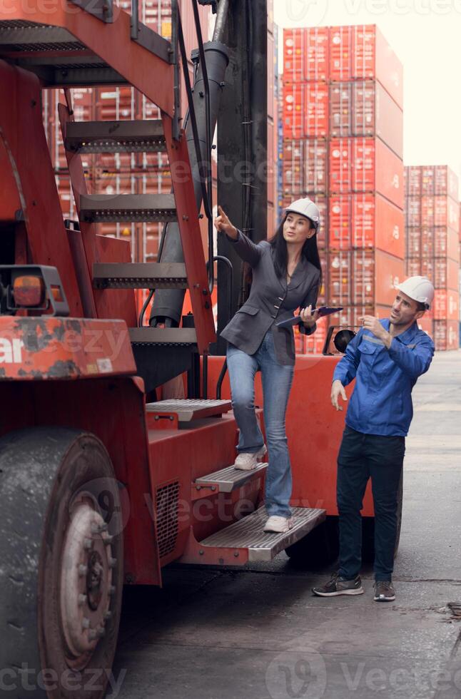 Container manufacturing manager and businesswomen survey the area to plan the storage and moving of goods in and out of the container storage area,142 photo