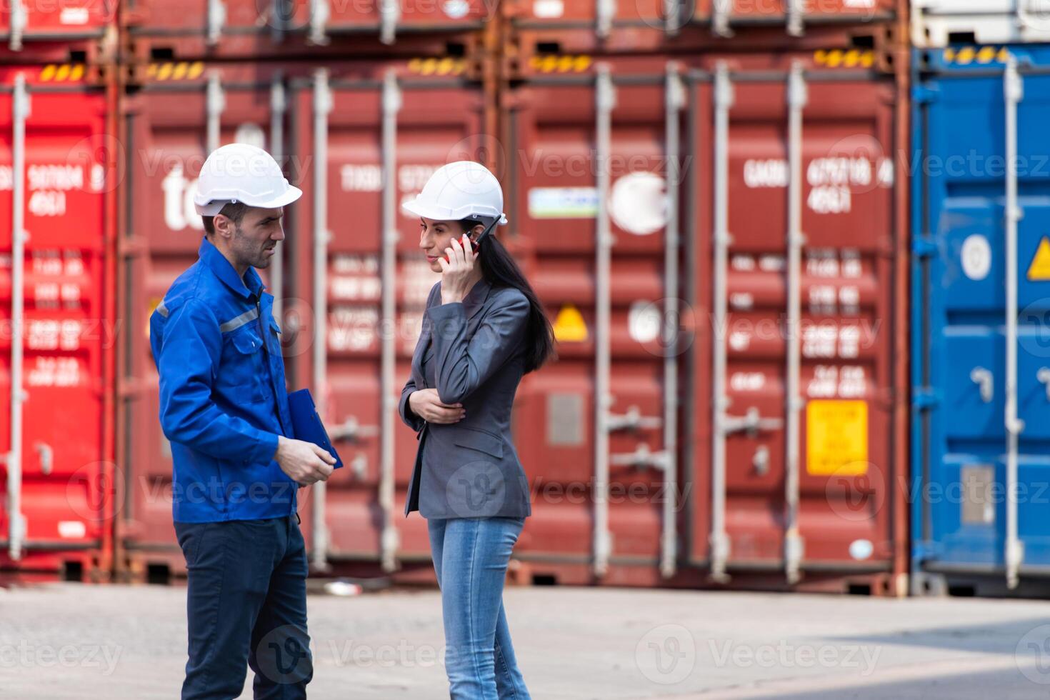 Container manufacturing manager and businesswomen survey the area to plan the storage and moving of goods in and out of the container storage area,141 photo