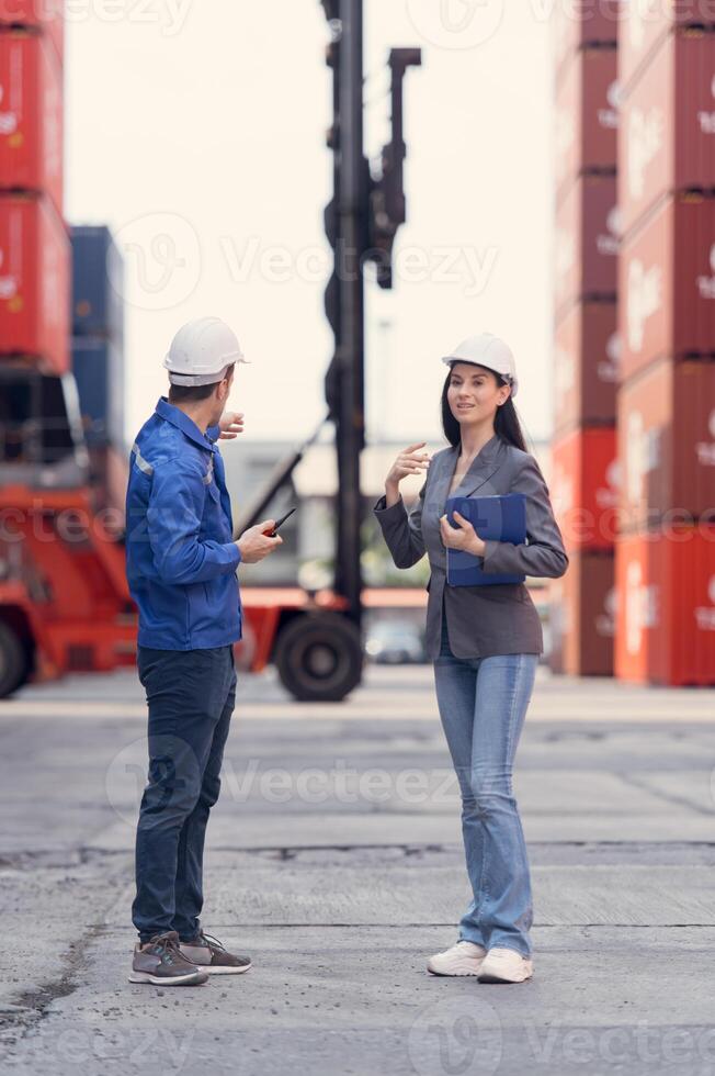 Container manufacturing manager and businesswomen survey the area to plan the storage and moving of goods in and out of the container storage area,127 photo