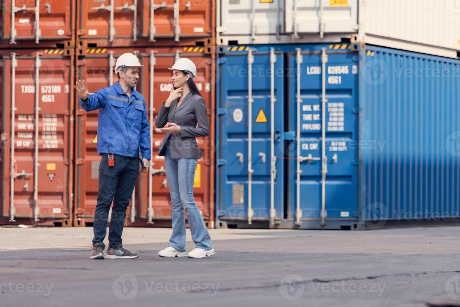 Container manufacturing manager and businesswomen survey the area to plan the storage and moving of goods in and out of the container storage area,124 photo