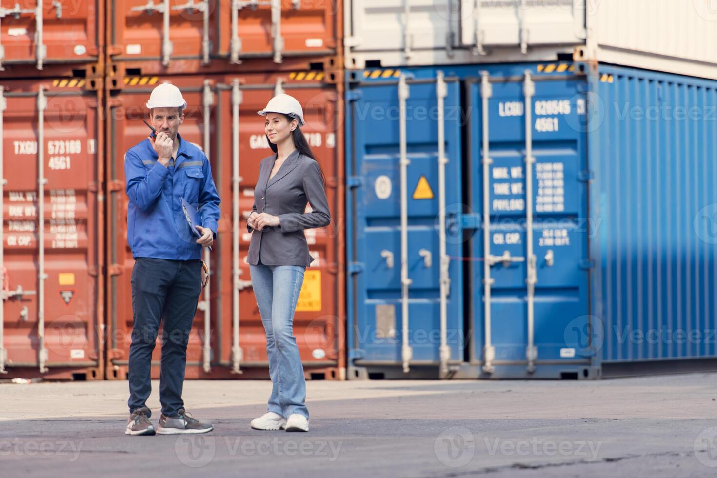 Container manufacturing manager and businesswomen survey the area to plan the storage and moving of goods in and out of the container storage area,121 photo