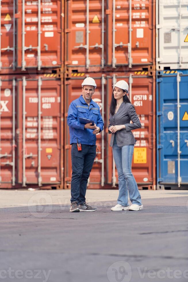 Container manufacturing manager and businesswomen survey the area to plan the storage and moving of goods in and out of the container storage area,122 photo