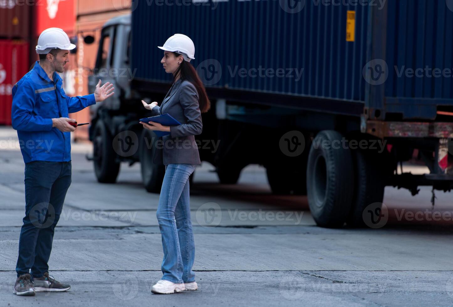 Container manufacturing manager and businesswomen survey the area to plan the storage and moving of goods in and out of the container storage area,115 photo