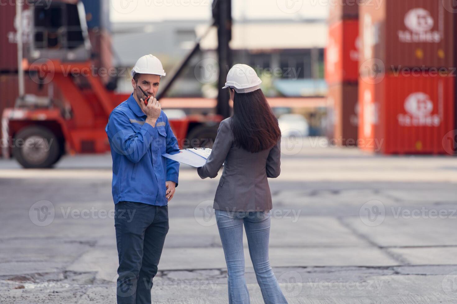 Container manufacturing manager and businesswomen survey the area to plan the storage and moving of goods in and out of the container storage area,114 photo