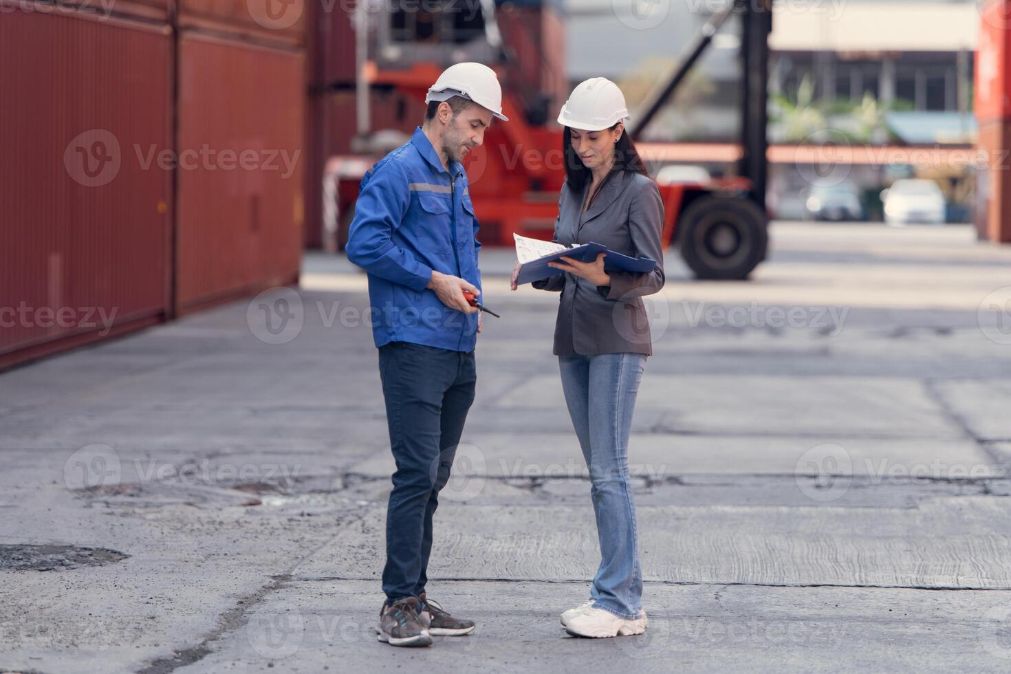 Container manufacturing manager and businesswomen survey the area to plan the storage and moving of goods in and out of the container storage area,113 photo
