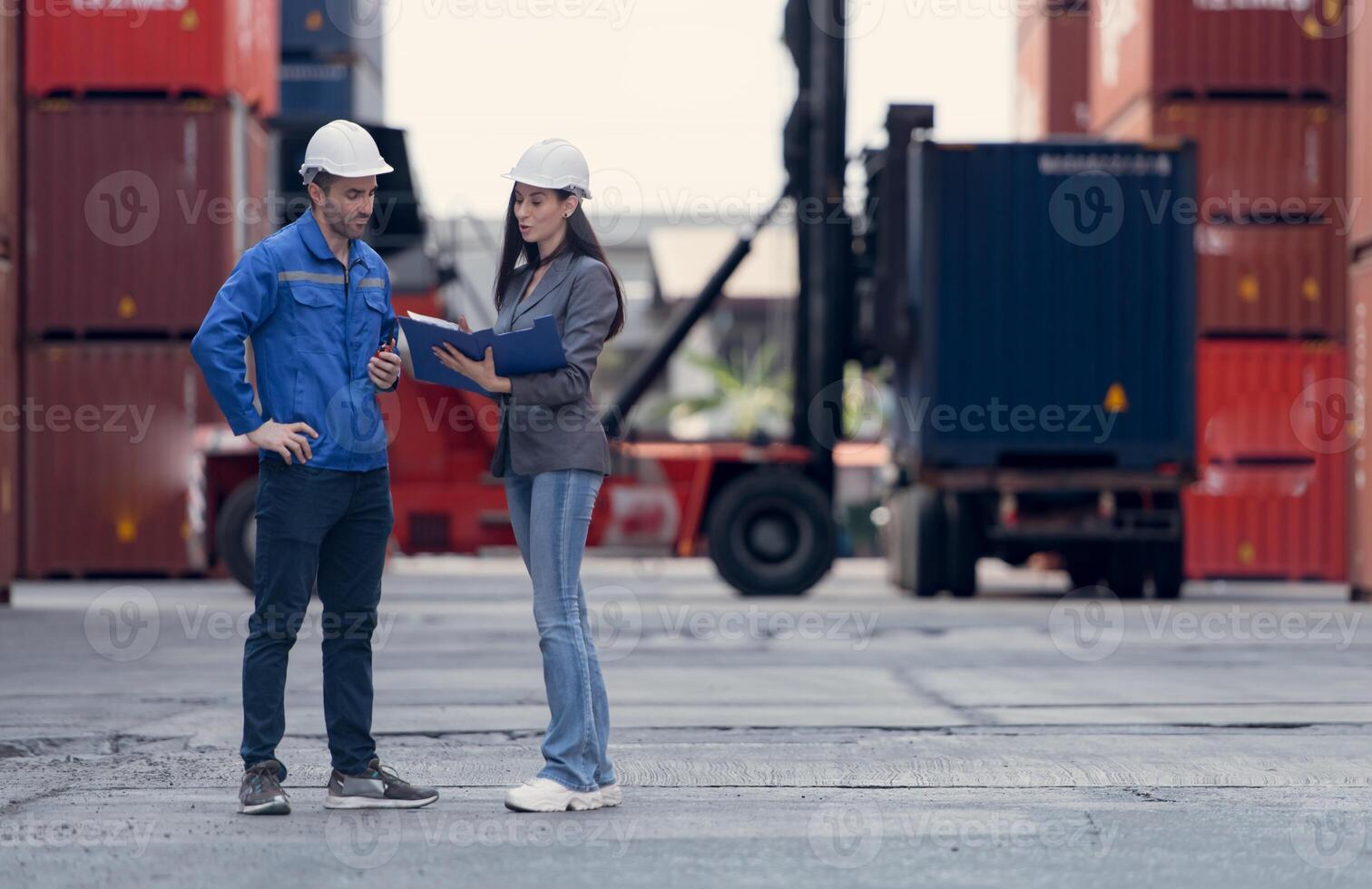 Container manufacturing manager and businesswomen survey the area to plan the storage and moving of goods in and out of the container storage area,111 photo