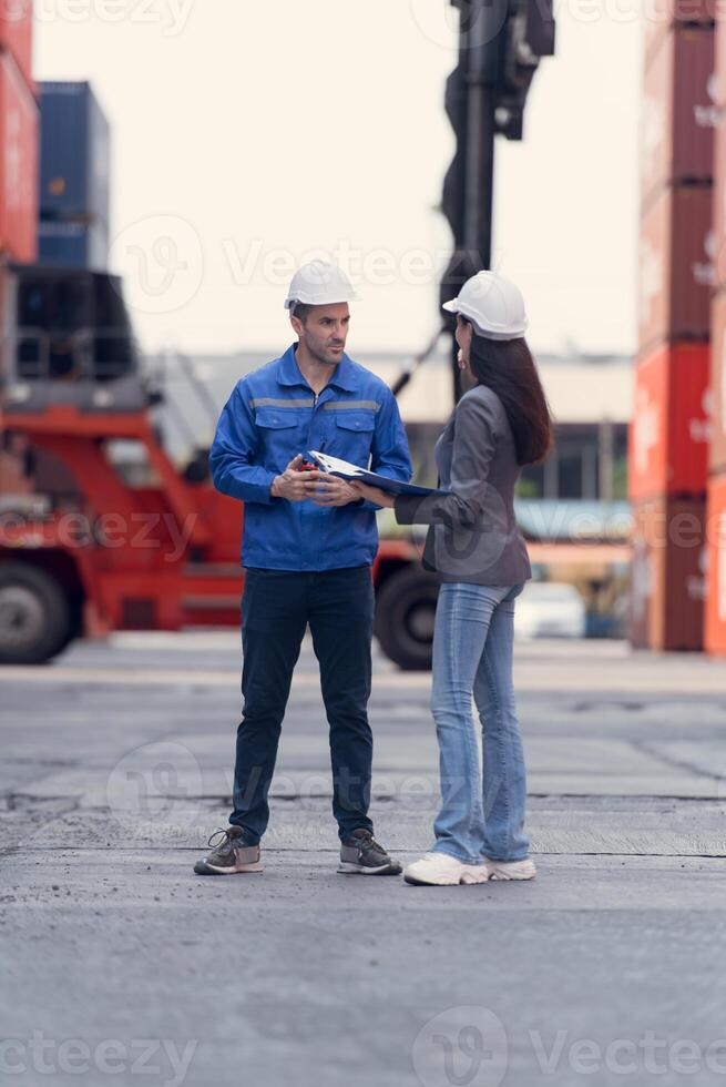 Container manufacturing manager and businesswomen survey the area to plan the storage and moving of goods in and out of the container storage area,104 photo