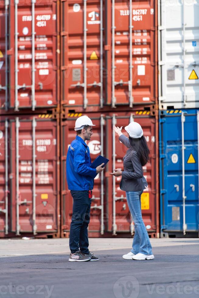 Container manufacturing manager and businesswomen survey the area to plan the storage and moving of goods in and out of the container storage area,99 photo