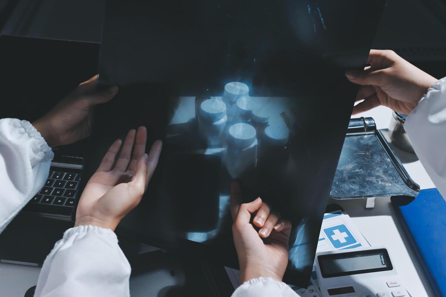 Hands of doctors examining x-ray image photo