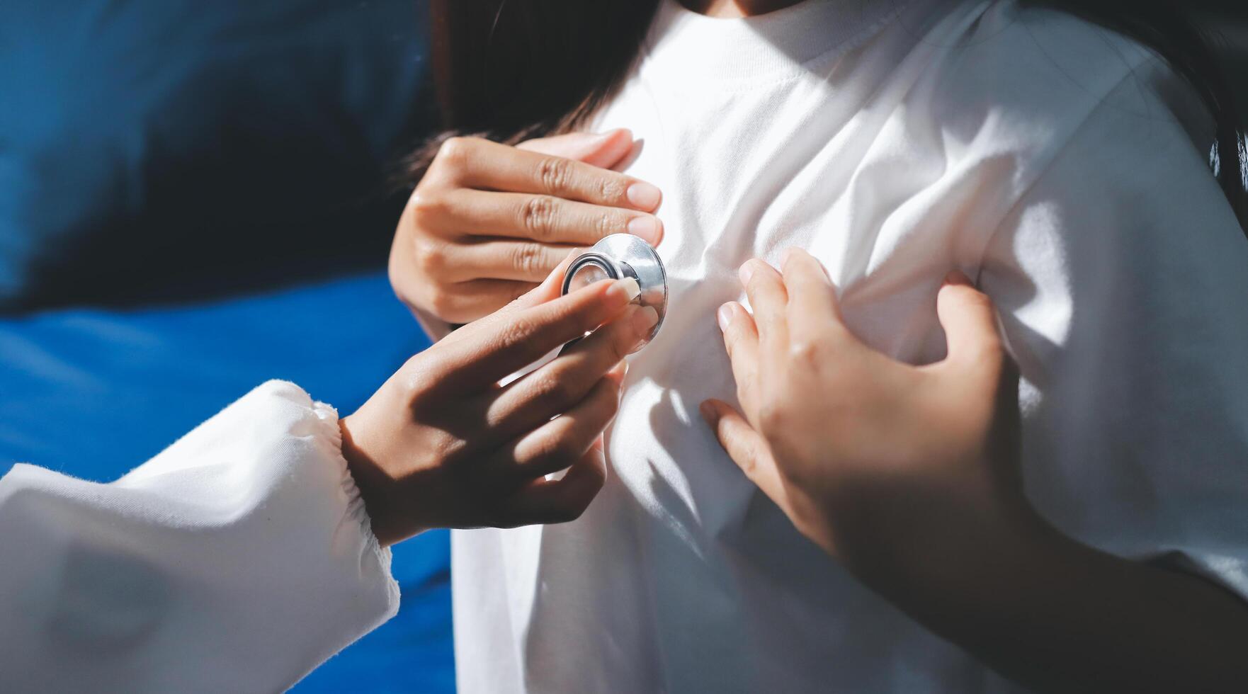 A woman is holding a stethoscope to a child's chest photo