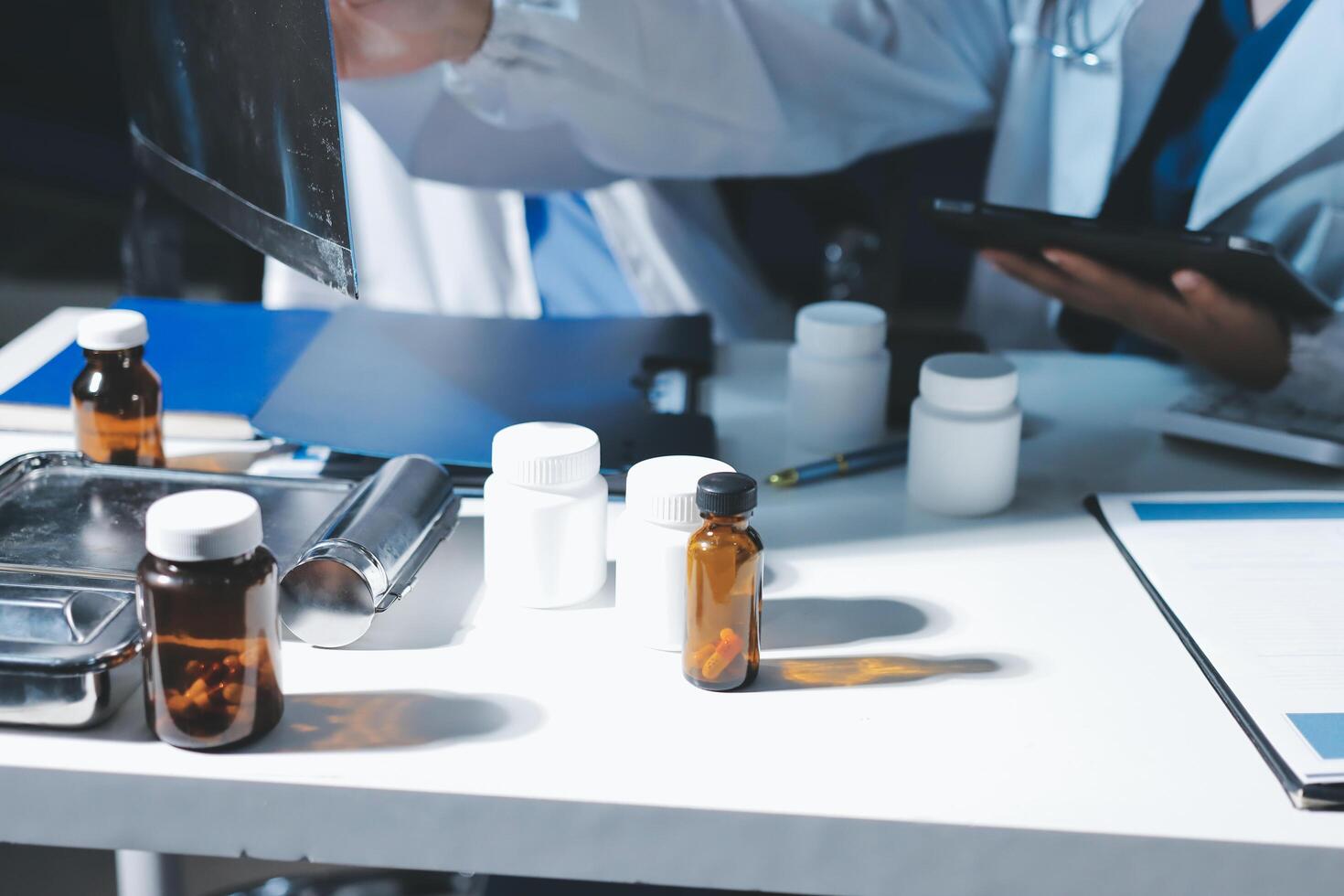 A doctor is holding a tablet computer and looking at a bottle photo