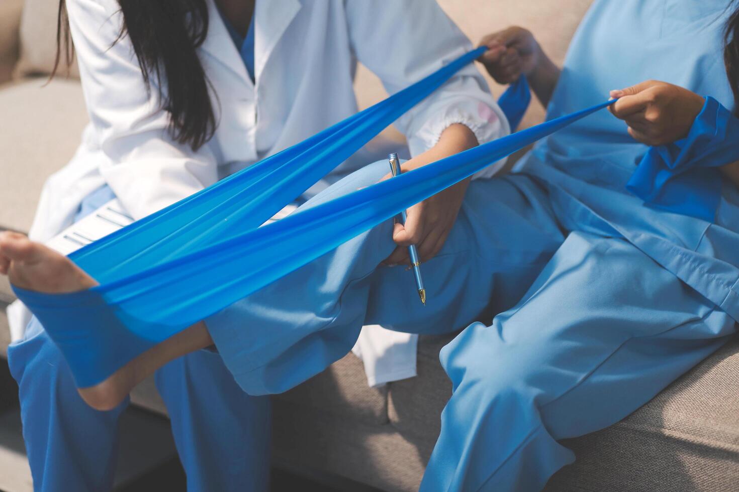 A woman in scrubs is holding a blue bandage to her leg photo