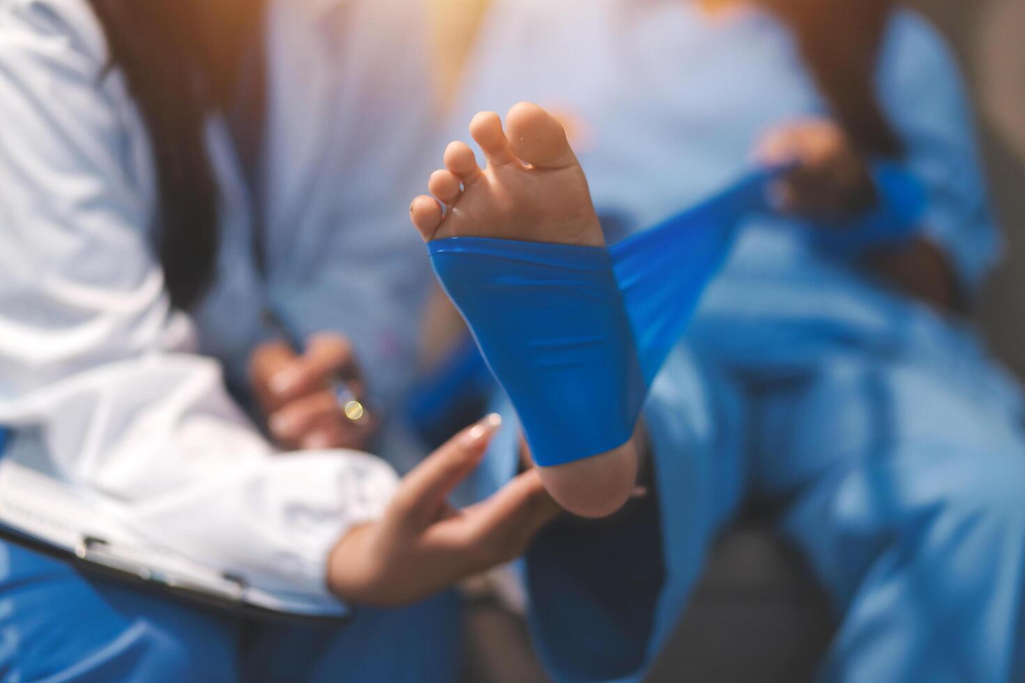 A doctor is holding a bandage to a patient's foot photo