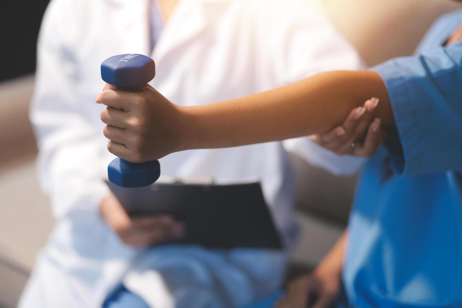 A doctor is holding a dumbbell while a nurse is sitting on a couch photo