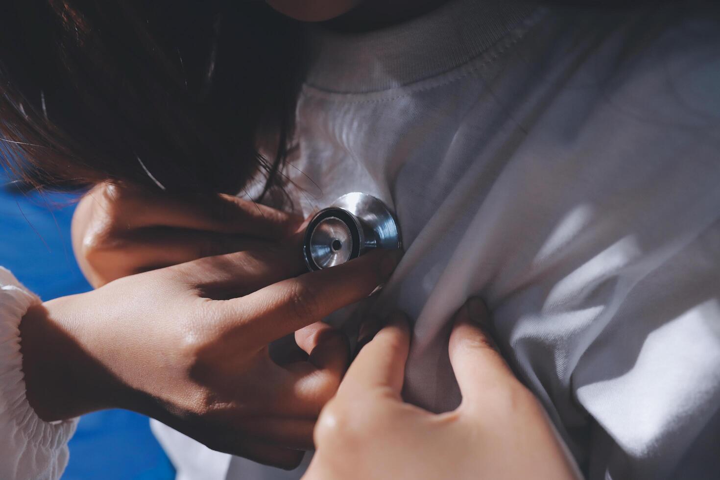 A person putting a stethoscope on someone's chest photo