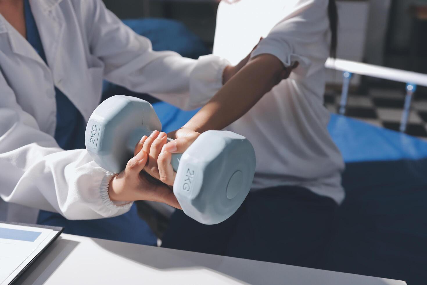 A woman is holding a dumbbell while a doctor is standing next to her photo
