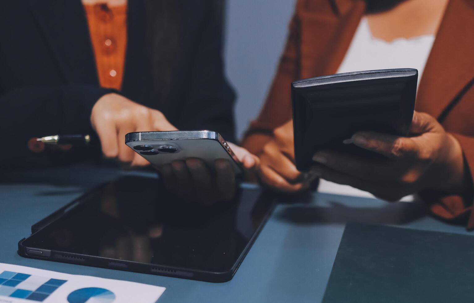 Two business people using their smartphones at a desk photo