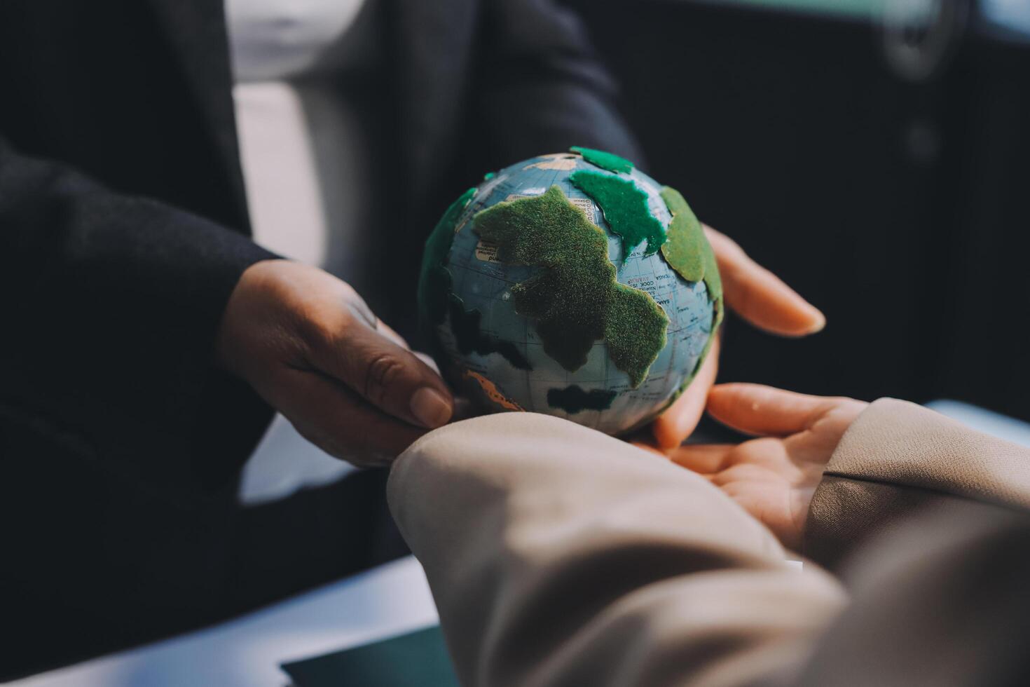 Business people holding a globe with a green and blue earth photo