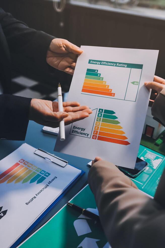 Business people holding papers with energy efficiency chart photo
