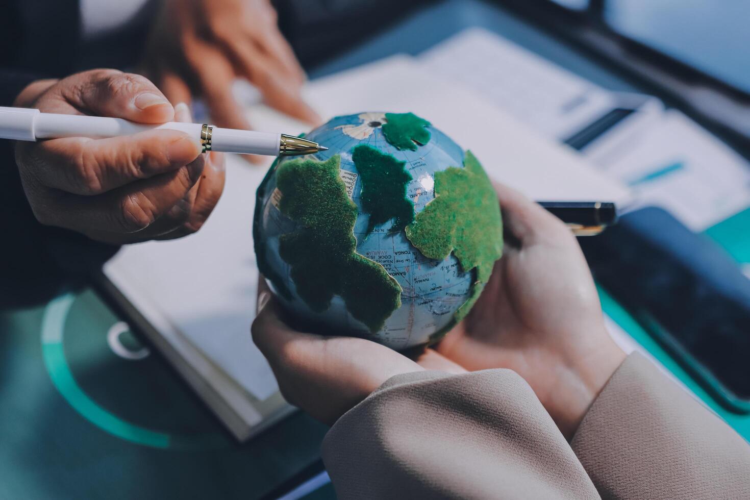 Business people holding a globe with a pen and a cigarette photo