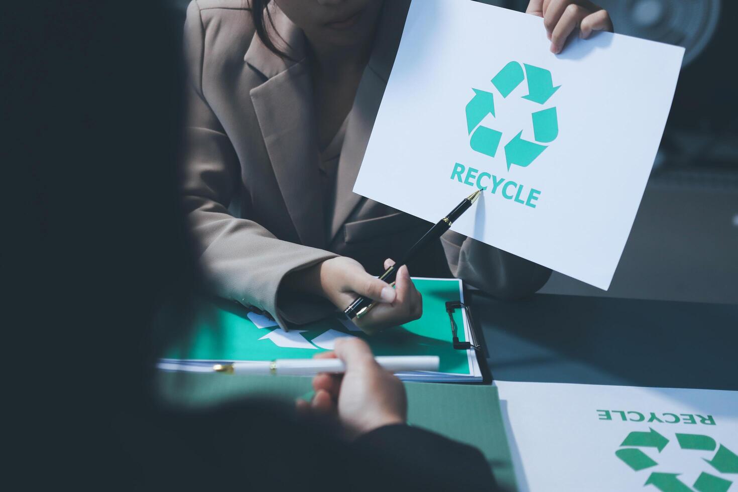 A woman holding a paper with a recycling symbol photo