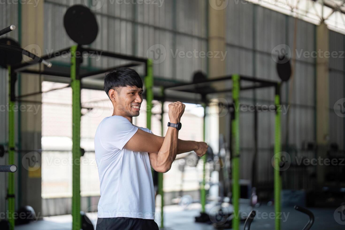 Strength and Flexibility. Young man stretching after workout in gym. photo